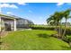 Lush green backyard featuring a screened-in pool with a view of the golf course at 17700 Sawgrass Run, Tavares, FL 32778
