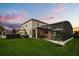 Expansive backyard with a screened-in pool, manicured lawn, and lush landscaping offers private relaxation at 17700 Sawgrass Run, Tavares, FL 32778