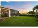Beautiful backyard featuring a screened-in pool, lush lawn, and serene views, perfect for outdoor living at 17700 Sawgrass Run, Tavares, FL 32778