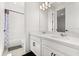 Bright bathroom with double sinks, white cabinets, and a shower with a bathtub at 17700 Sawgrass Run, Tavares, FL 32778