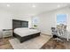 Well-lit bedroom featuring a wooden headboard bed, side tables, desk, and chair for a functional living space at 17700 Sawgrass Run, Tavares, FL 32778