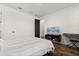 Well-lit bedroom showcasing a television set, a white-striped bed, and wood-look flooring at 17700 Sawgrass Run, Tavares, FL 32778
