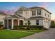 Stunning two-story home with lush landscaping, stone accents, and an attached two-car garage on a large lot at 17700 Sawgrass Run, Tavares, FL 32778
