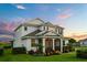 Attractive two-story home boasts a well-maintained lawn, lush landscaping, and inviting screened entryway at 17700 Sawgrass Run, Tavares, FL 32778