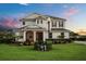Inviting two-story home featuring manicured landscaping, warm exterior lighting, and a welcoming covered entryway at 17700 Sawgrass Run, Tavares, FL 32778