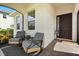 Inviting covered front porch features comfortable seating and a stylish entrance at 17700 Sawgrass Run, Tavares, FL 32778