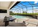 Inviting screened-in pool area featuring outdoor seating, dining set, and picturesque views of lush landscape at 17700 Sawgrass Run, Tavares, FL 32778