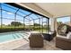 Relaxing screened-in pool area with an outdoor lounge, dining set, and stunning golf course views at 17700 Sawgrass Run, Tavares, FL 32778