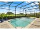 A refreshing screened-in pool and patio set against the backdrop of a lush green golf course at 17700 Sawgrass Run, Tavares, FL 32778