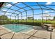 Screened in pool with patio table set with chairs and golf course view at 17700 Sawgrass Run, Tavares, FL 32778