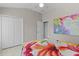 Cozy bedroom features bright floral bedding, closet space, and natural light at 2077 Vickers Pl, The Villages, FL 32163