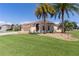 Lovely single-story home with a lush green lawn and mature palm trees at 2077 Vickers Pl, The Villages, FL 32163