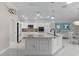 White kitchen boasts stainless steel appliances, granite countertops, and modern lighting fixtures at 2077 Vickers Pl, The Villages, FL 32163