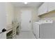 Functional laundry room with white cabinets, counter space, and modern washer and dryer at 2077 Vickers Pl, The Villages, FL 32163