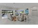 Open-concept living room with neutral tones, tile floors, and sliding glass doors leading to an outdoor area at 2077 Vickers Pl, The Villages, FL 32163