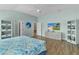 Bright main bedroom boasts wood floors, light walls, and ensuite bathroom access at 2077 Vickers Pl, The Villages, FL 32163