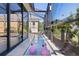 View of the screened-in pool area with decorative pink flamingoes in the shallow end and sliding glass doors to the home at 2077 Vickers Pl, The Villages, FL 32163