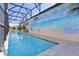 Long, screened-in pool with a mural, travertine tile decking, and dark bronze support beams at 2077 Vickers Pl, The Villages, FL 32163