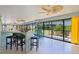 Bright sunroom featuring tile flooring, ceiling fans and a bar with stools at 2077 Vickers Pl, The Villages, FL 32163