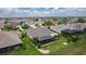 An aerial view of a home with a screened lanai in a neighborhood with lush landscaping and palm trees at 2082 Vision Ct, The Villages, FL 32163