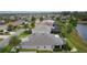 Aerial view of a single-Gathering home near a lake, featuring a screened-in patio and mature trees at 2082 Vision Ct, The Villages, FL 32163