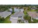 Aerial view showcasing a single-story home with a three-car garage, paver driveway, and serene lake at 2082 Vision Ct, The Villages, FL 32163