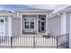 Covered front entry and patio features updated tile, a bench, and black metal fencing at 2082 Vision Ct, The Villages, FL 32163