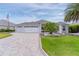 Charming home featuring a three car garage, well maintained lawn, and tropical landscaping at 2082 Vision Ct, The Villages, FL 32163