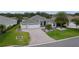 Beautiful single-story home with a three-car garage, manicured lawn, and elegant paver driveway at 2082 Vision Ct, The Villages, FL 32163