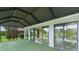 Enclosed lanai with sliding glass doors and green indoor/outdoor carpet flooring with a scenic backyard view at 2082 Vision Ct, The Villages, FL 32163