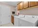 Laundry room featuring a utility sink, washer, dryer, and upper cabinets at 2082 Vision Ct, The Villages, FL 32163