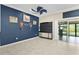 Living room with dark blue accent wall, art decorations, tile floors, and sliding glass doors at 2082 Vision Ct, The Villages, FL 32163