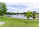 Beautiful pond view surrounded by lush green grass and mature trees at 2082 Vision Ct, The Villages, FL 32163