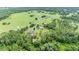 Aerial view featuring the home, barn, surrounding trees, and acreage at 21320 Paradise Way, Eustis, FL 32736