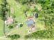 Aerial view of the home and property showing trees, a pond, and outbuildings at 21320 Paradise Way, Eustis, FL 32736