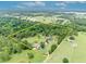 Aerial view of the property showing the house, outbuildings, pond, and tree coverage at 21320 Paradise Way, Eustis, FL 32736