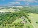Aerial view of the property with a yellow border including home, pond, outbuildings, and surrounding trees at 21320 Paradise Way, Eustis, FL 32736