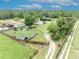 Aerial view of property showcasing the house, pool, barn, and tree-lined boundaries at 21320 Paradise Way, Eustis, FL 32736
