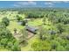 Aerial view of property featuring a house, barn, paddocks, and mature trees at 21320 Paradise Way, Eustis, FL 32736
