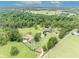 Aerial view featuring the home, barn, surrounding trees, and acreage at 21320 Paradise Way, Eustis, FL 32736