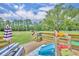 Back deck showing seating, slide, and backyard with greenery and tree line at 21320 Paradise Way, Eustis, FL 32736