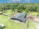 Aerial shot of large barn and paddock area with mature trees, ideal for equestrian use at 21320 Paradise Way, Eustis, FL 32736
