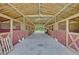 Barn interior showing stalls, concrete flooring, support beams, and storage at 21320 Paradise Way, Eustis, FL 32736