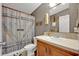 Neutral bathroom featuring a single sink vanity and toilet with barn door shower curtain at 21320 Paradise Way, Eustis, FL 32736