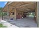 Side view of a covered horse barn showing stalls with wooden framing and doors plus the concrete floor at 21320 Paradise Way, Eustis, FL 32736