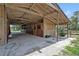 Angle view of the covered horse barn showing the stalls, concrete floor, and open center aisle at 21320 Paradise Way, Eustis, FL 32736