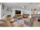 Comfortable living room features a large television, stone fireplace and three comfortable sofas at 21320 Paradise Way, Eustis, FL 32736