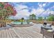 Outdoor above ground pool with a wooden deck, lounge chairs, and blooming Crepe Myrtle trees at 21320 Paradise Way, Eustis, FL 32736