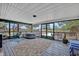 Enclosed outdoor patio with comfortable seating, hot tub, and view of the fenced backyard at 21320 Paradise Way, Eustis, FL 32736