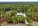 Aerial view of the charming home surrounded by lush greenery shows great curb appeal and peaceful surroundings at 2163 County Road 243F, Wildwood, FL 34785